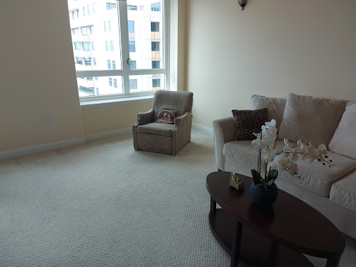 A cozy living room featuring a comfortable sofa and armchair with ample natural light from the large window.