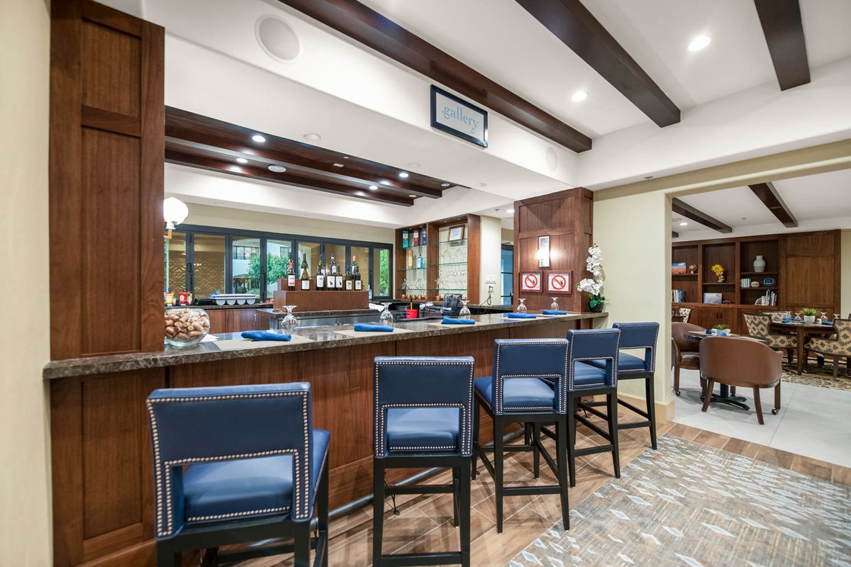 A stylish modern bar interior with wooden beams and blue seating.