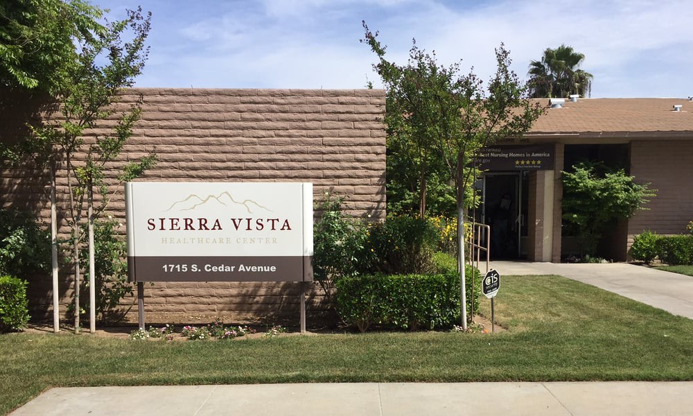 Entrance to Sierra Vista with a sign and landscaped surroundings.