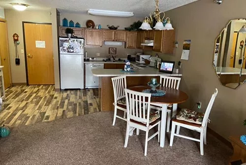 Cozy kitchen and dining area with wooden cabinets and a round table.