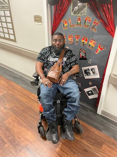 A man in a wheelchair enjoying a celebration, surrounded by festive decorations.