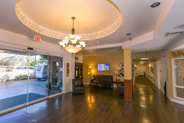 A well-lit lobby with a chandelier and seating area near the entrance.