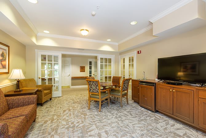 A cozy living room featuring comfortable seating, a television, and wooden cabinets, creating a welcoming ambiance.