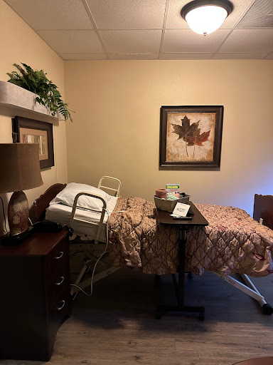 A cozy hospital room with a bed, bedside table, and decorative elements.
