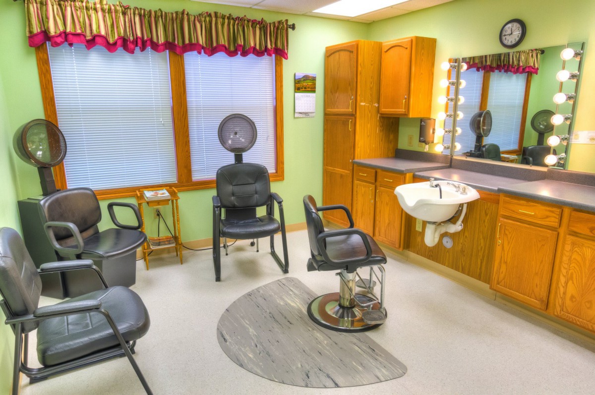 A cozy hair salon with styling chairs, a mirror, and a sink setup.