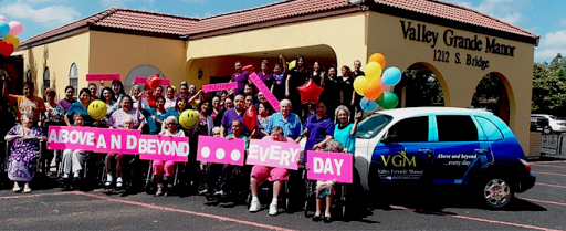 A vibrant gathering of community members celebrating together with colorful signs and balloons.