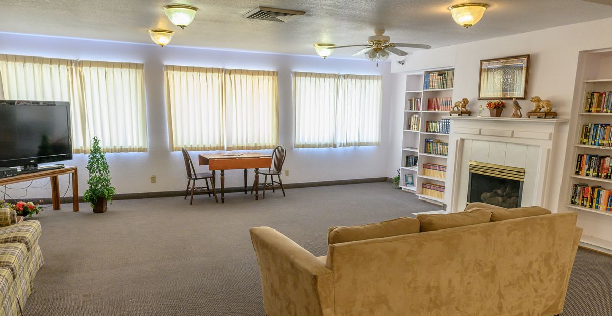 A cozy living room with a bookshelf, table, and sofa.