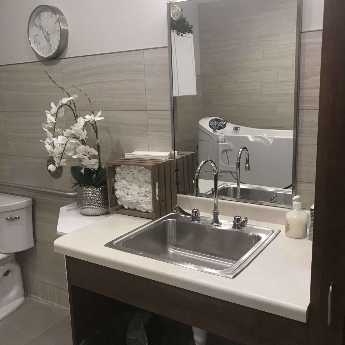 A well-organized bathroom with a sink, mirror, and floral decor.