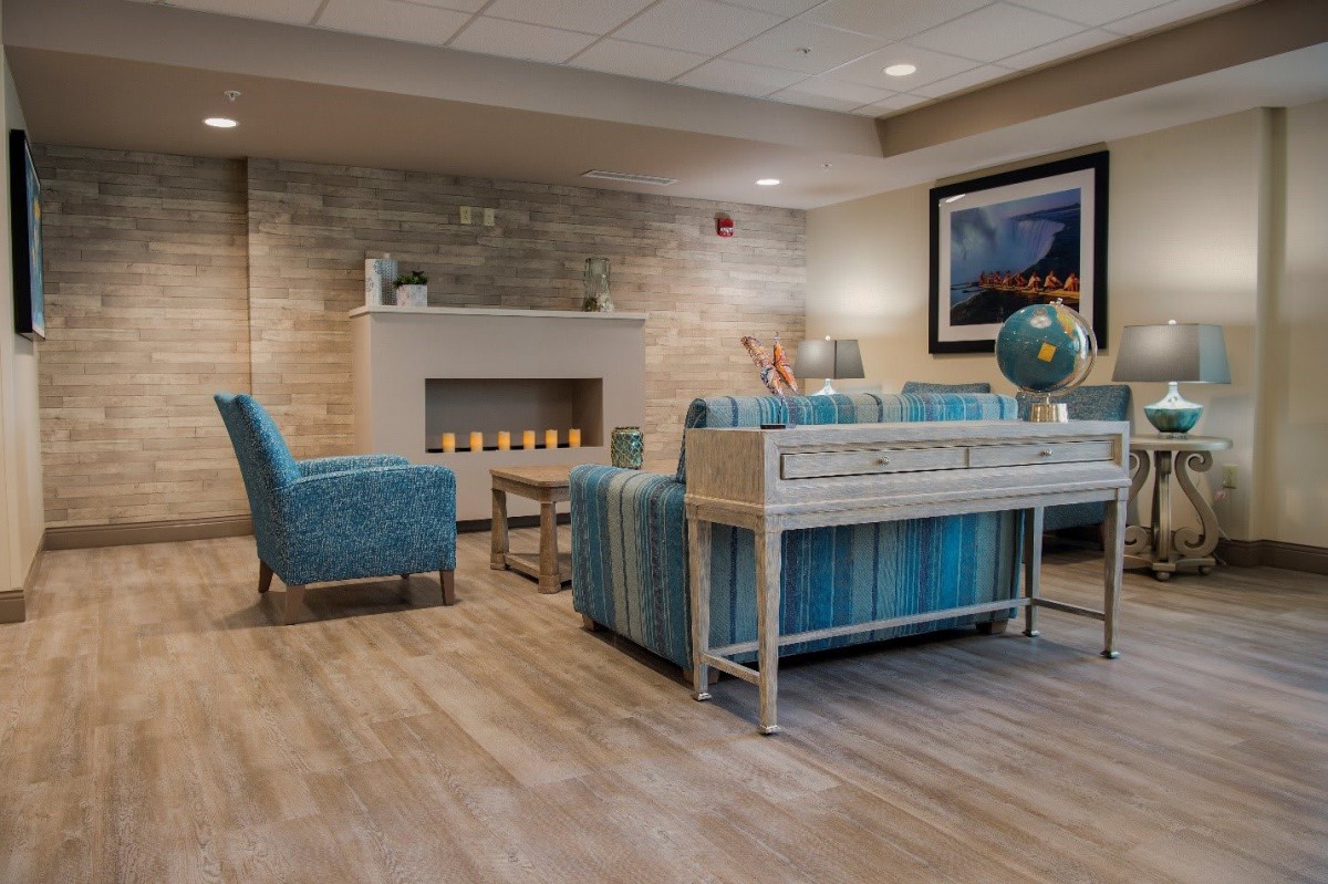 A cozy and modern living room with blue furniture and a fireplace.