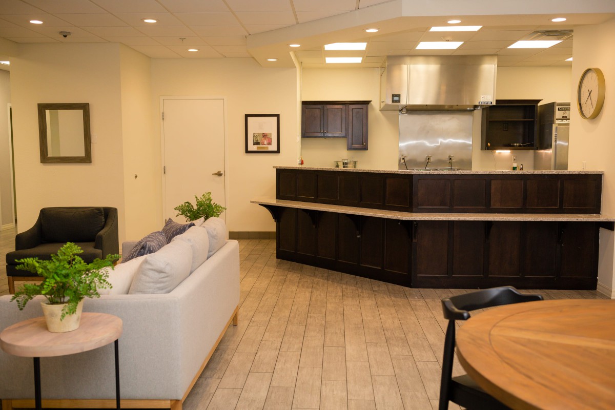 A modern open-plan kitchen and living area featuring sleek cabinetry and comfortable seating.