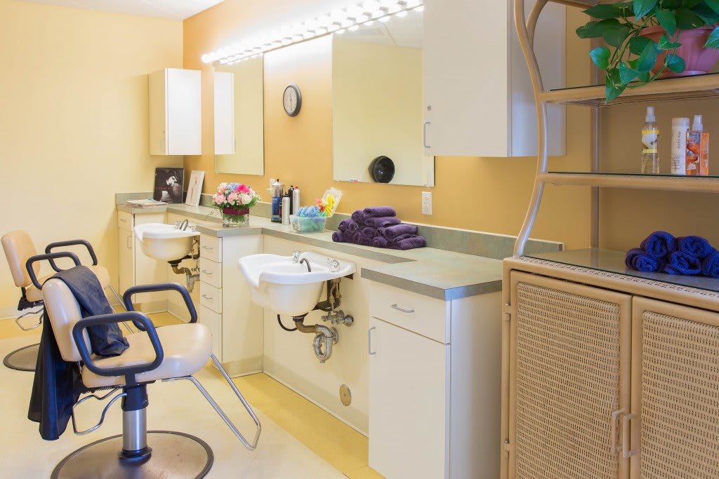 A well-lit hair salon interior with chairs, mirrors, and sinks.