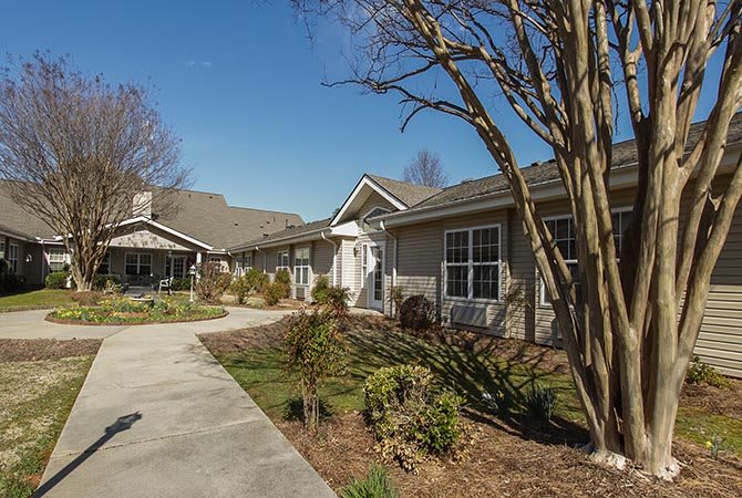 A residential house with a landscaped garden and clear weather.