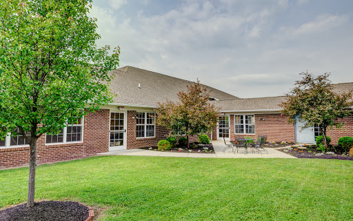 A beautiful residential building surrounded by well-maintained landscaping and lush green grass.