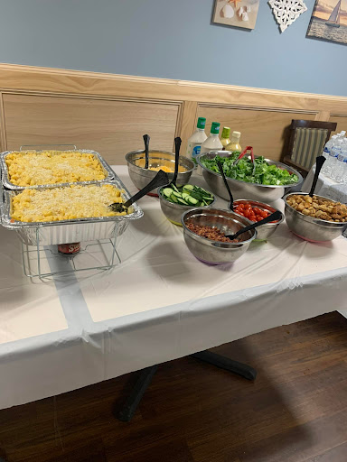 A selection of dishes at a buffet setup, featuring salads and a cheesy casserole.