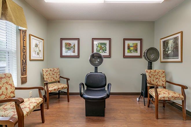 A cozy salon interior with chairs and hair dryers, adorned with framed artwork on the walls.