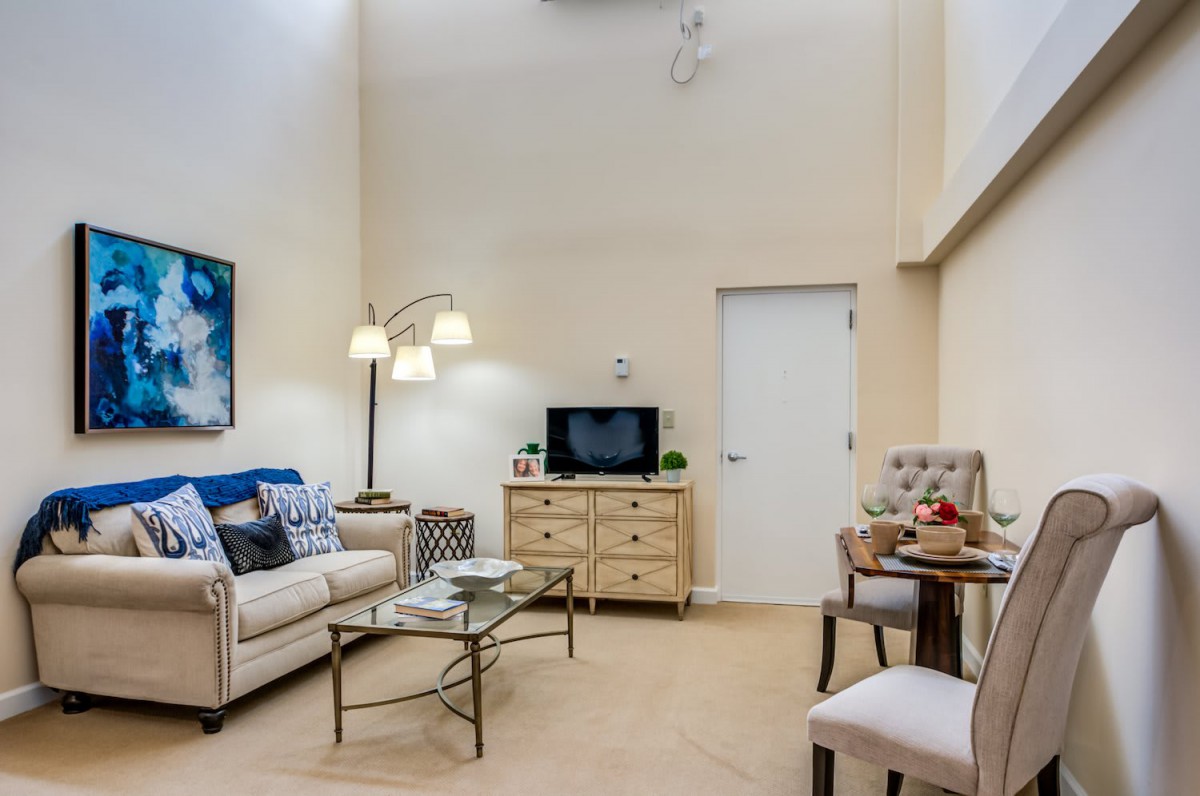 A cozy living room with a sofa, TV, and stylish decor.
