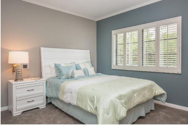 A cozy bedroom with a neatly made bed and soft neutral tones.