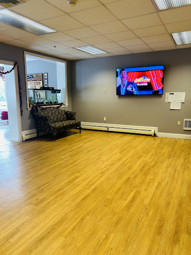 A spacious waiting area featuring a comfortable couch, a television, and an aquarium.