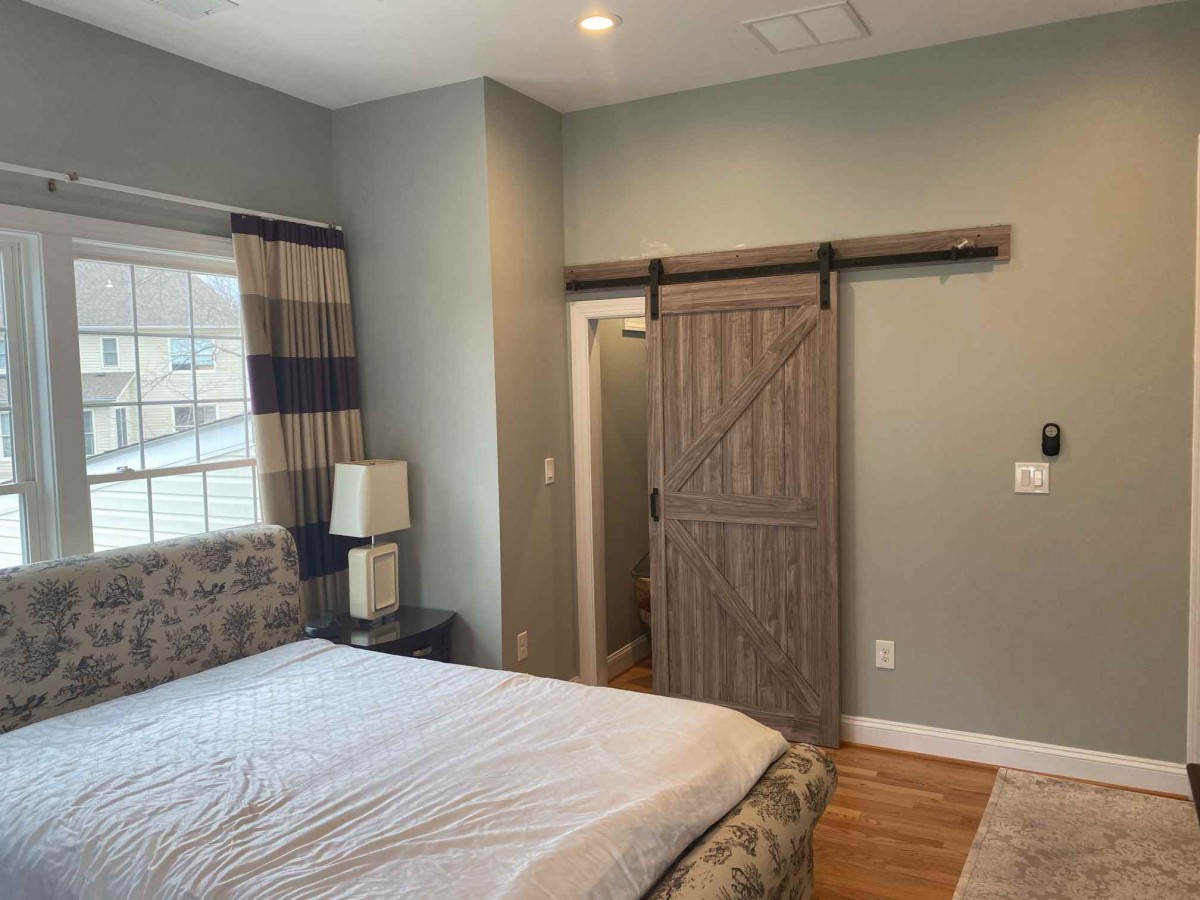 A cozy bedroom featuring a barn door and stylish interior design.