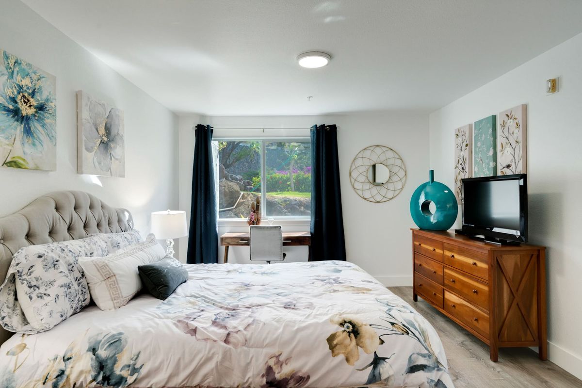 A modern bedroom interior with a comfortable bed, stylish decor, and a window letting in natural light.