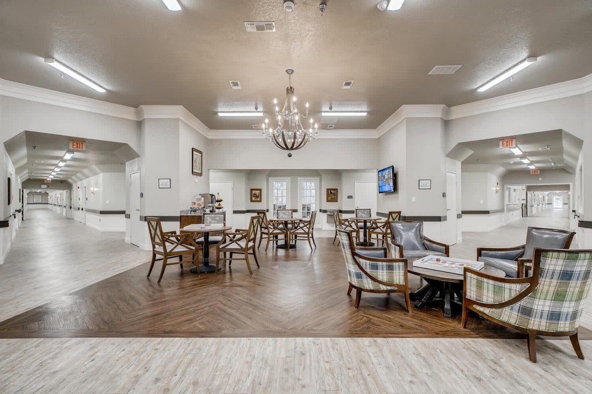 A spacious and modern dining area with elegant furnishings and a chandelier.