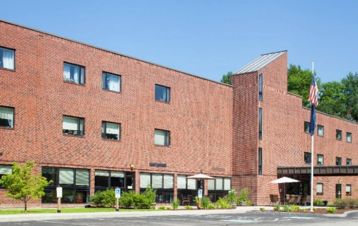 A brick building with multiple windows on a sunny day.