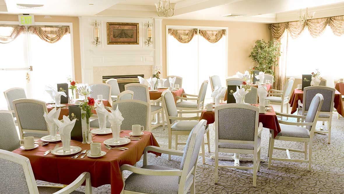 An elegant dining room with neatly arranged tables and chairs, featuring a warm and inviting decor.