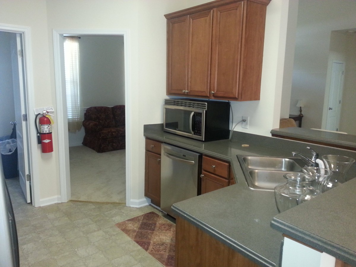 A modern kitchen with wooden cabinets and stainless steel appliances.