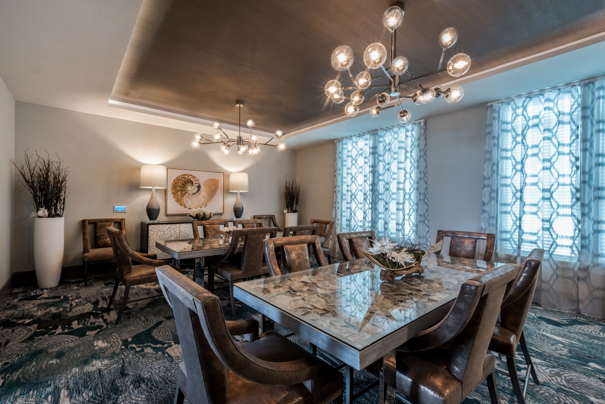 A luxurious dining room with elegant chandeliers and a stylish table setup.