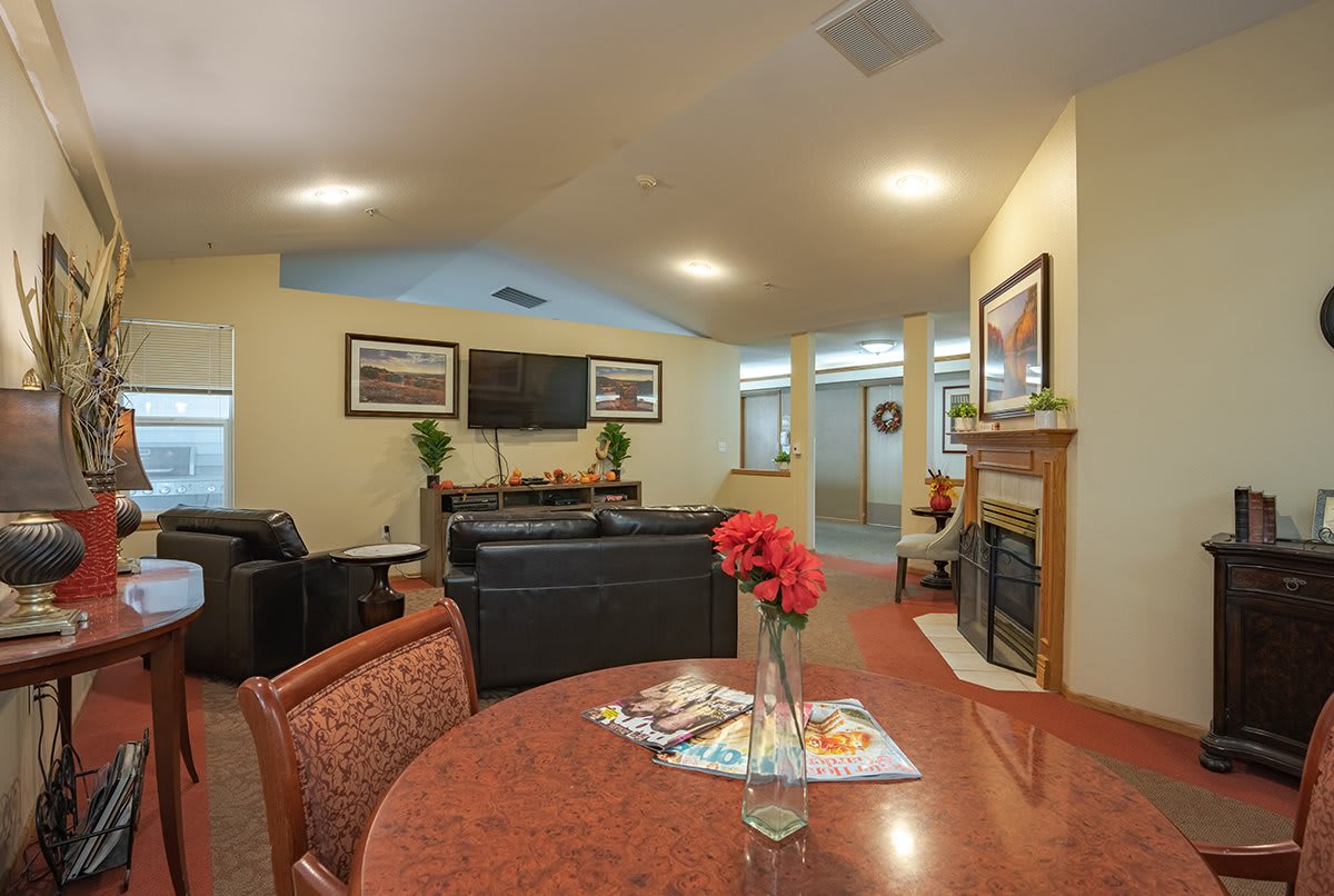 A cozy living room featuring a fireplace, comfortable seating, and a TV.