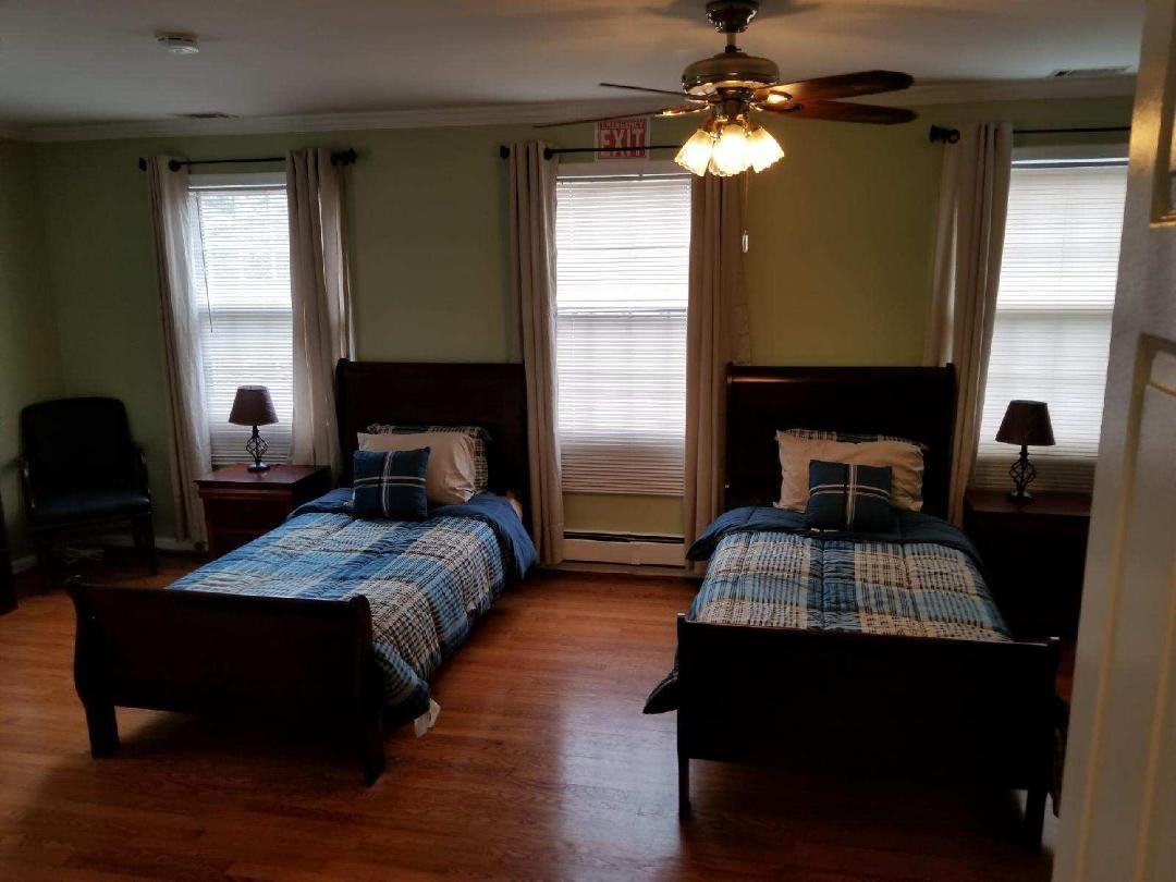 A cozy bedroom with twin beds and wooden flooring.