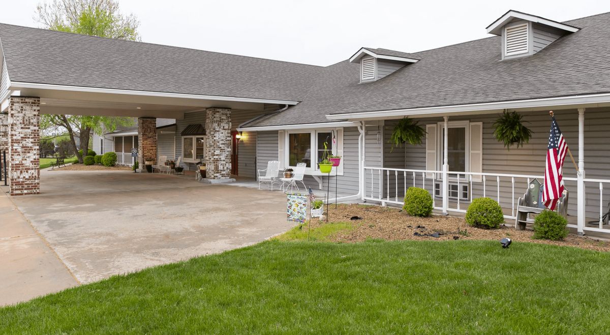 A view of a suburban house with a driveway and well-maintained lawn.