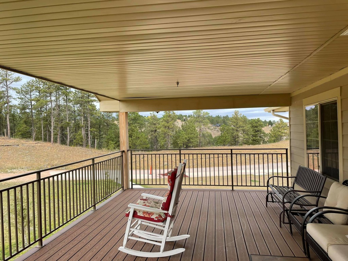 A peaceful covered porch with a rocking chair and scenic views.