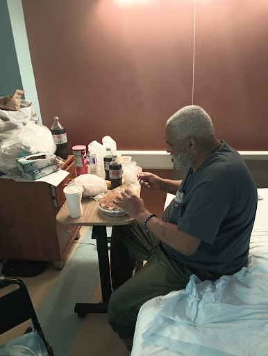 A patient enjoying a meal at a hospital bedside.
