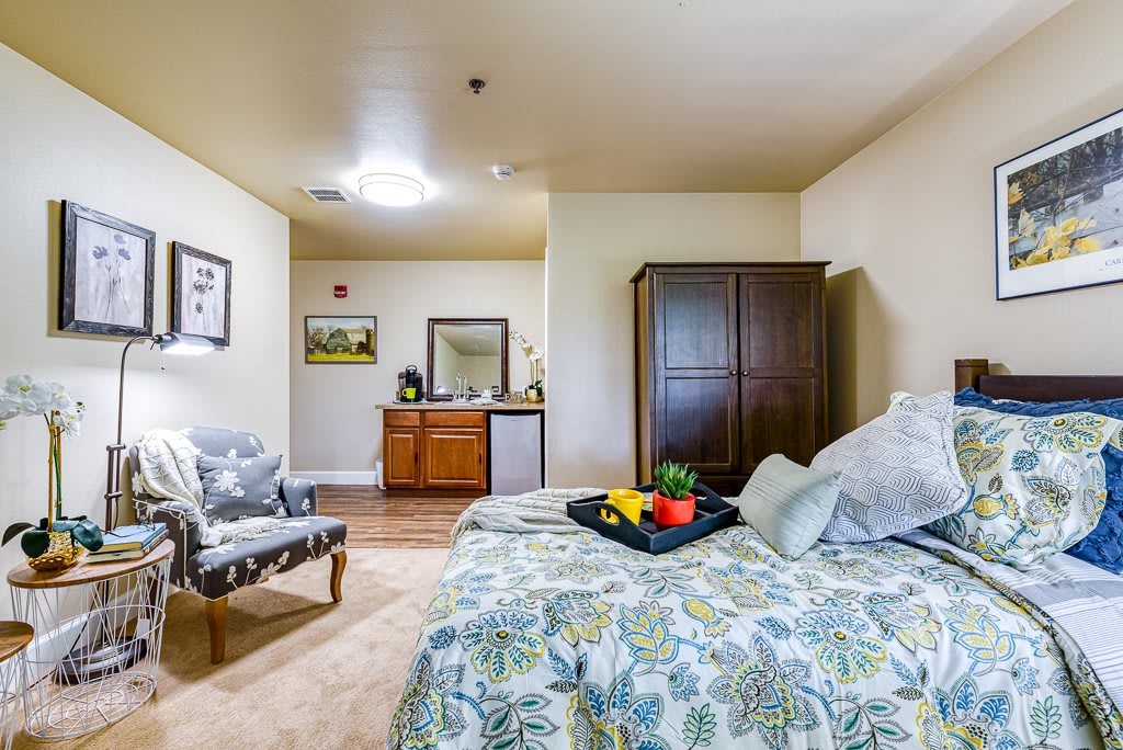 A cozy bedroom with a bed, wardrobe, and decorative elements.