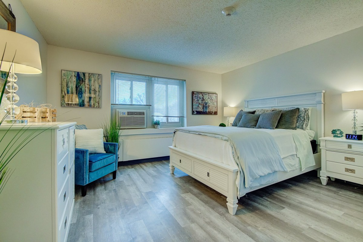 A cozy bedroom with a large bed, armchair, and stylish decor.