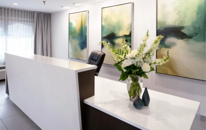 A modern reception area with abstract artwork and a floral arrangement.