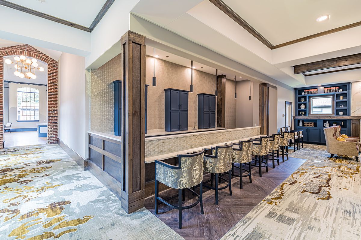 A modern bar area with sleek counter seating and elegant lighting.