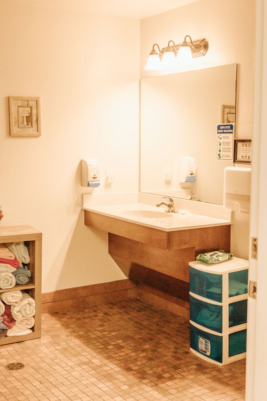A cozy bathroom with a sink, mirror, and organized storage shelves.