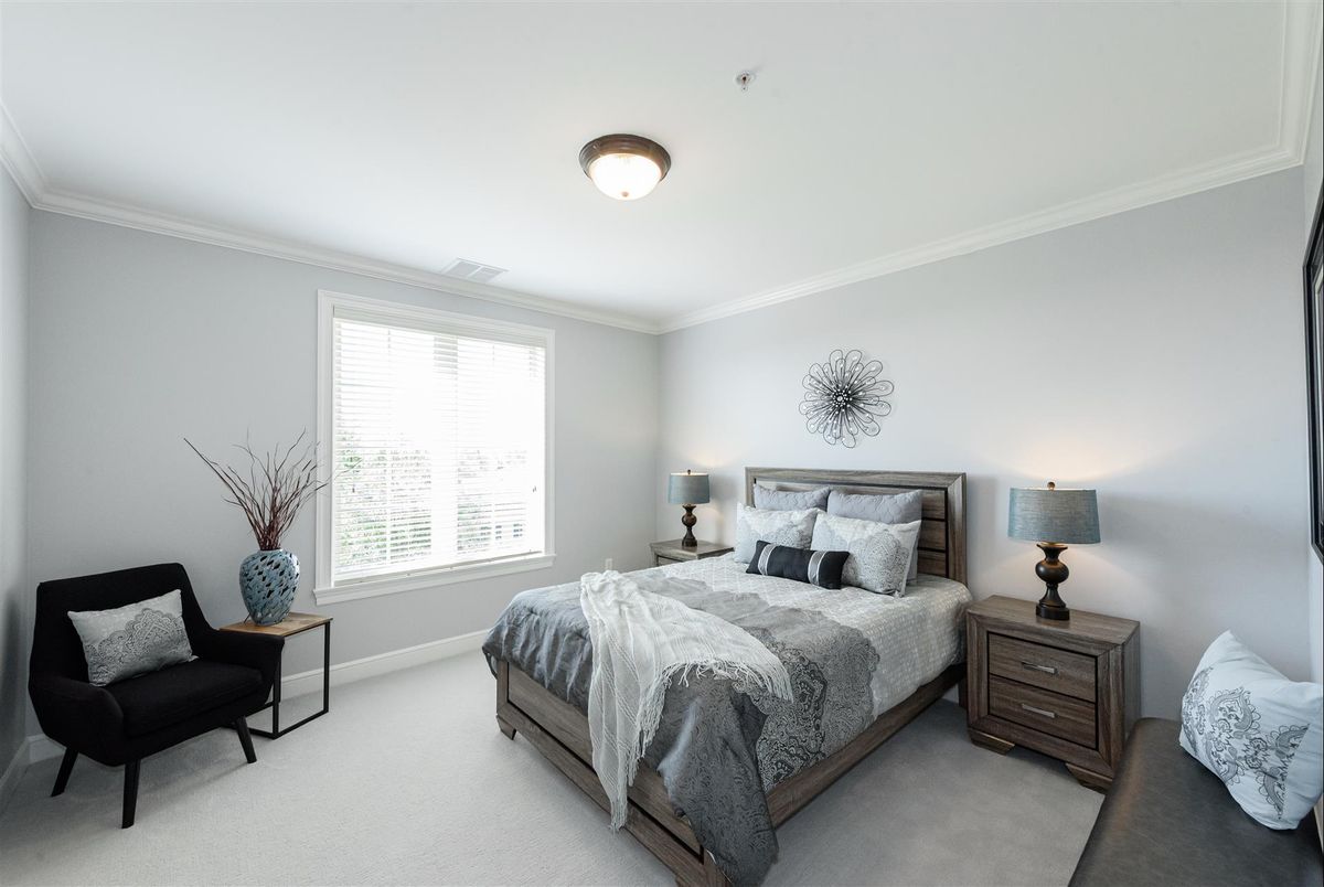 A modern and elegantly furnished bedroom with neutral tones and stylish decor.