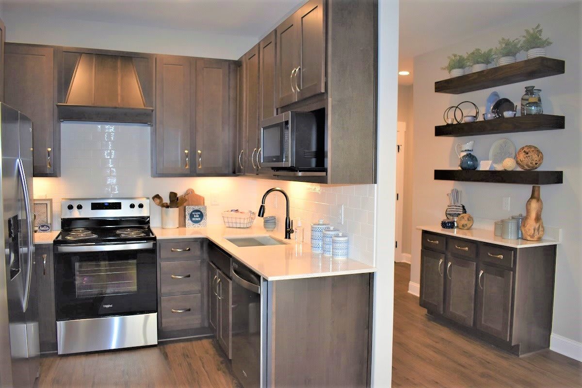 A modern kitchen interior with dark wood cabinets and stainless steel appliances.