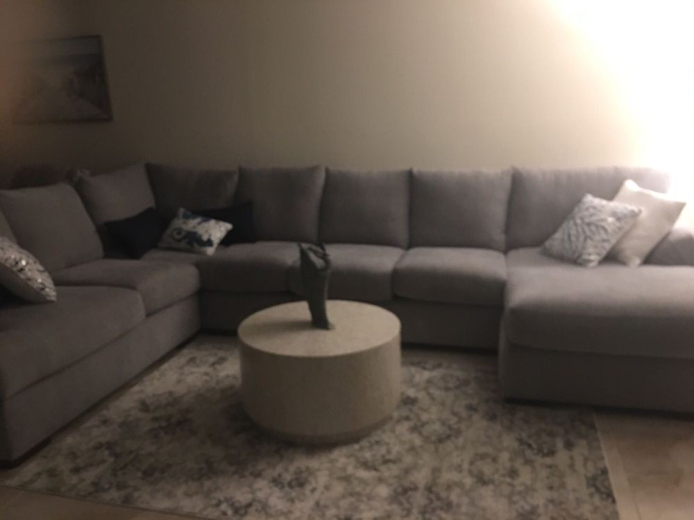 A cozy living room with a gray sectional sofa and a round coffee table.