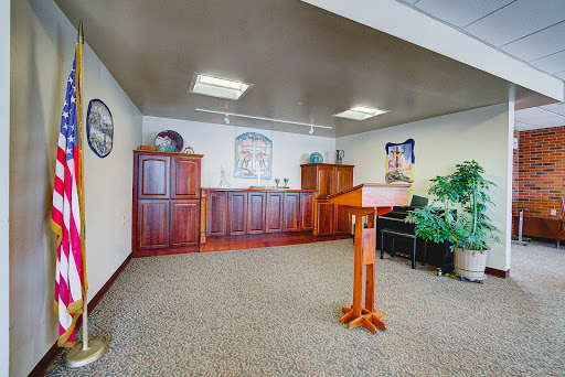 A well-furnished office space featuring a podium, wooden cabinets, and decorative plants.
