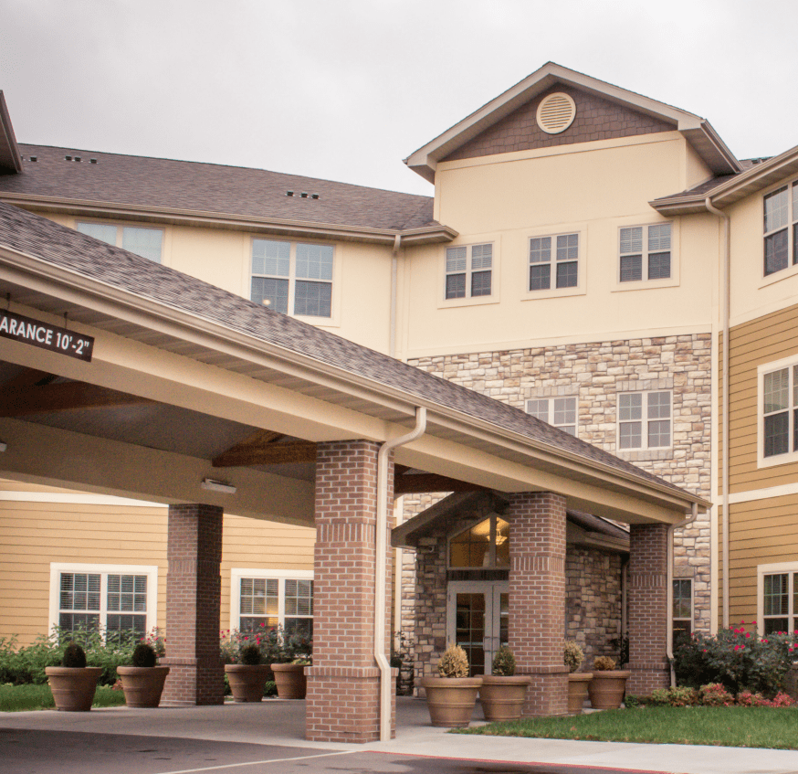 A residential building with a covered entrance and stonework facade.