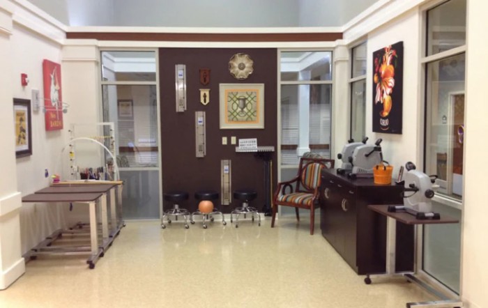 A well-decorated waiting room with chairs and various artworks adorning the walls.