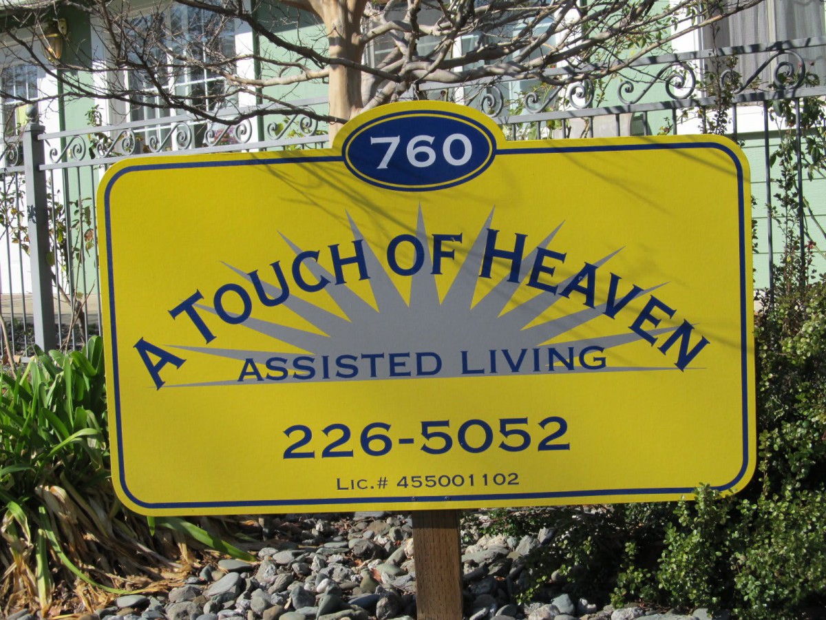 A sign for 'A Touch of Heaven Assisted Living' with contact details.