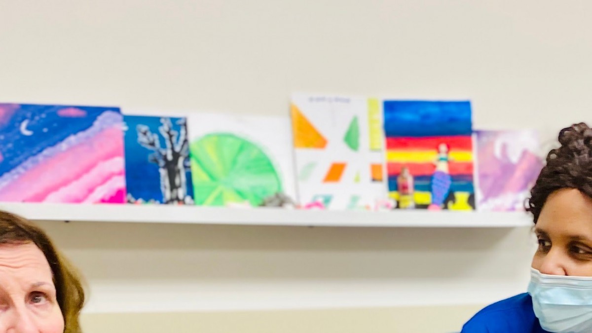 A series of colorful artworks displayed on a shelf.