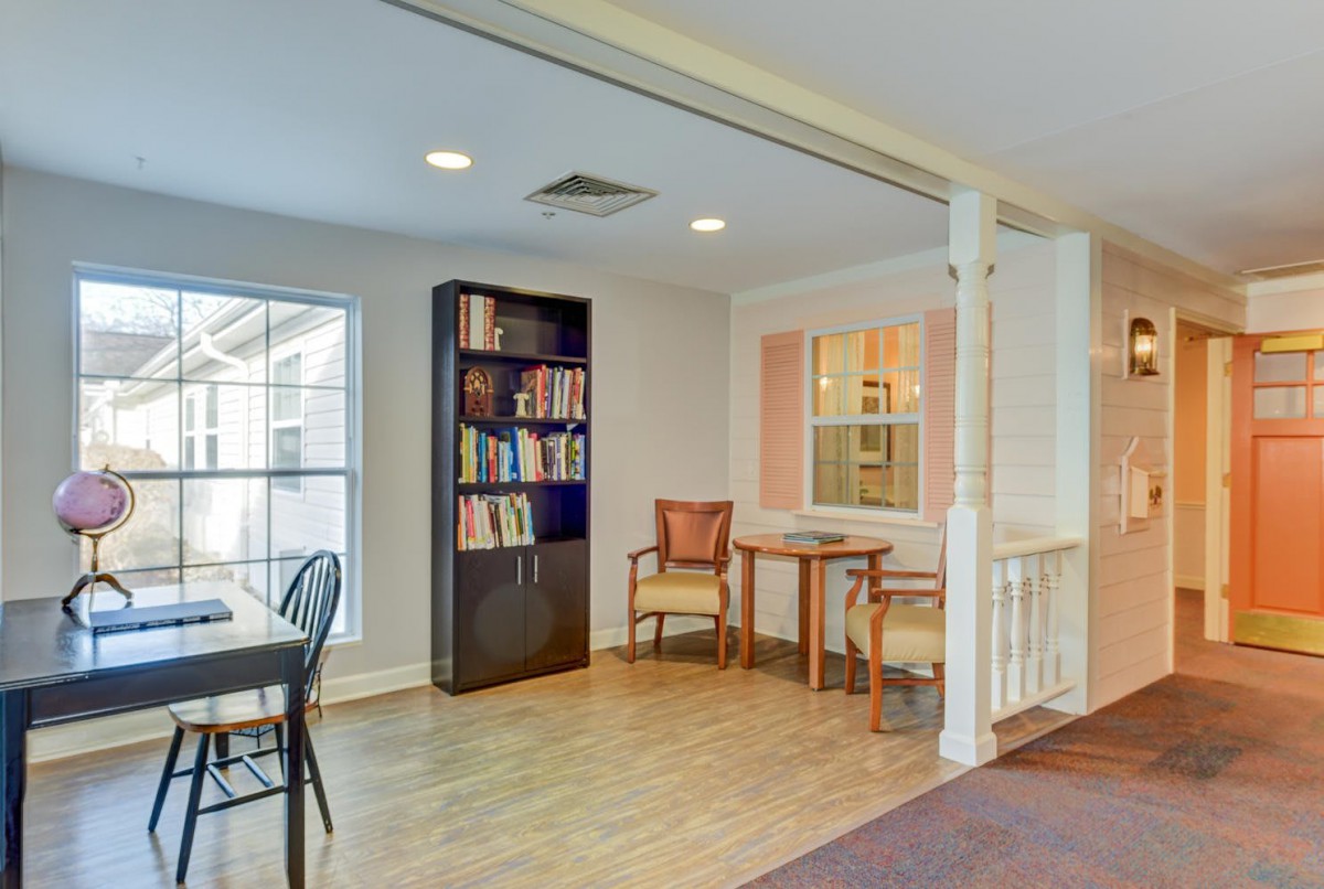 A cozy living room with a bookshelf and seating area.