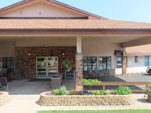 A welcoming entrance to a well-maintained building with lush landscaping.