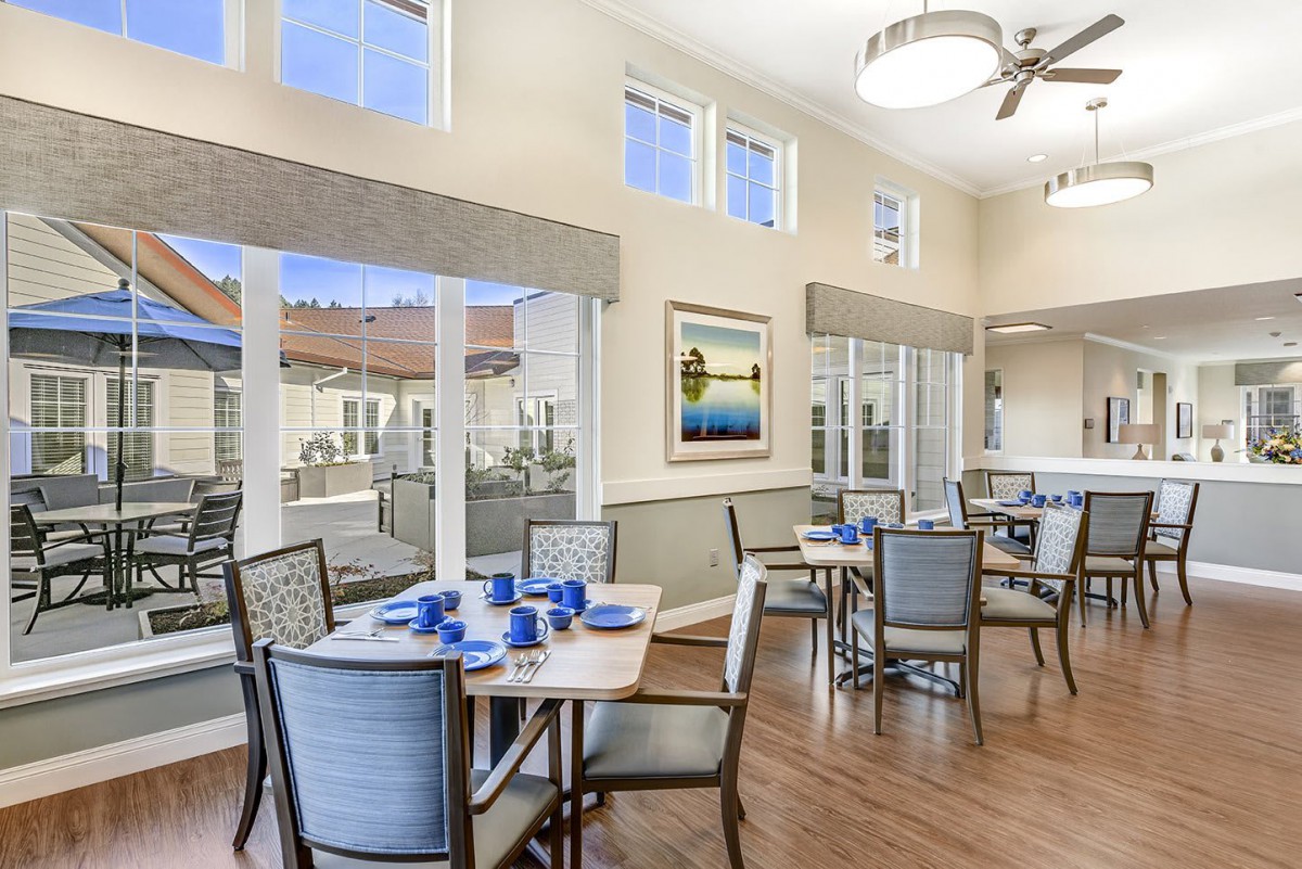 A bright and spacious dining room with neatly arranged tables and chairs.